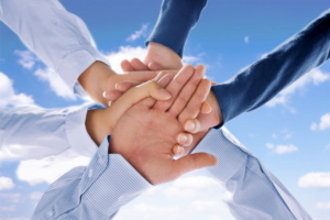 Close up view of hands getting together on blue background