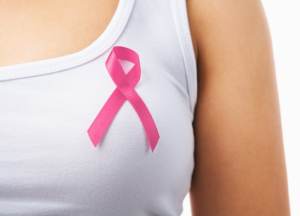 Close up of pink badge on woman chest to support breat cancer cause, PS: you can change the ribbon color to red to support AIDS cause as both using same symbol
